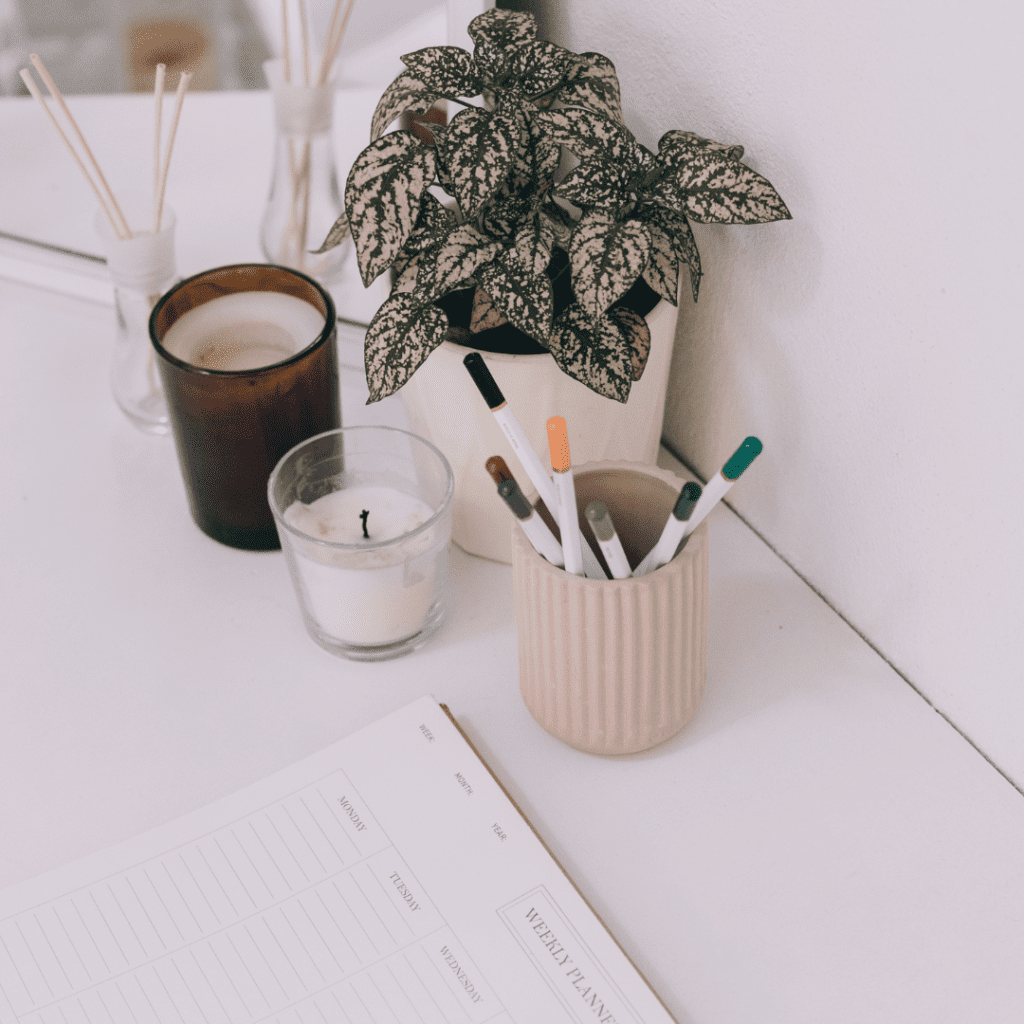 a notebook, candles and a plant on a table, image for website home page